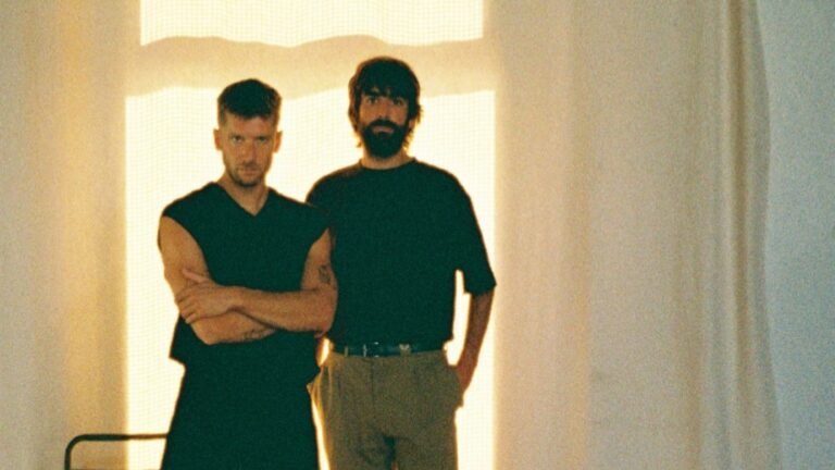 Emili Bosch i Malcus Codolà, membres del duet electrònic b1n0, en una sala il·luminada per una llum càlida