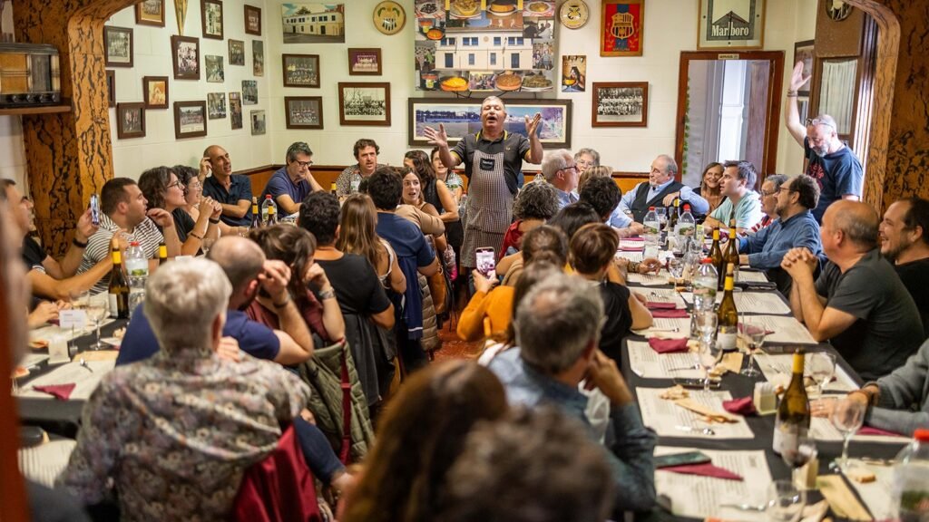 Dinar de cantadors del festival Càntut a Cassà de la Selva, amb comensals cantant al voltant de les taules