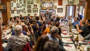 Dinar de cantadors del festival Càntut a Cassà de la Selva, amb comensals cantant al voltant de les taules