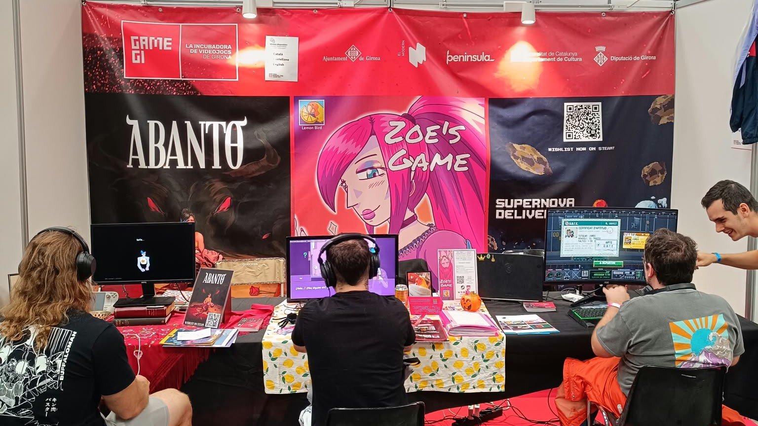 Estand de la incubadora de videojocs GameGi d'El Modern al SAGA Barcelona Game Fest amb jugadors provant els jocs